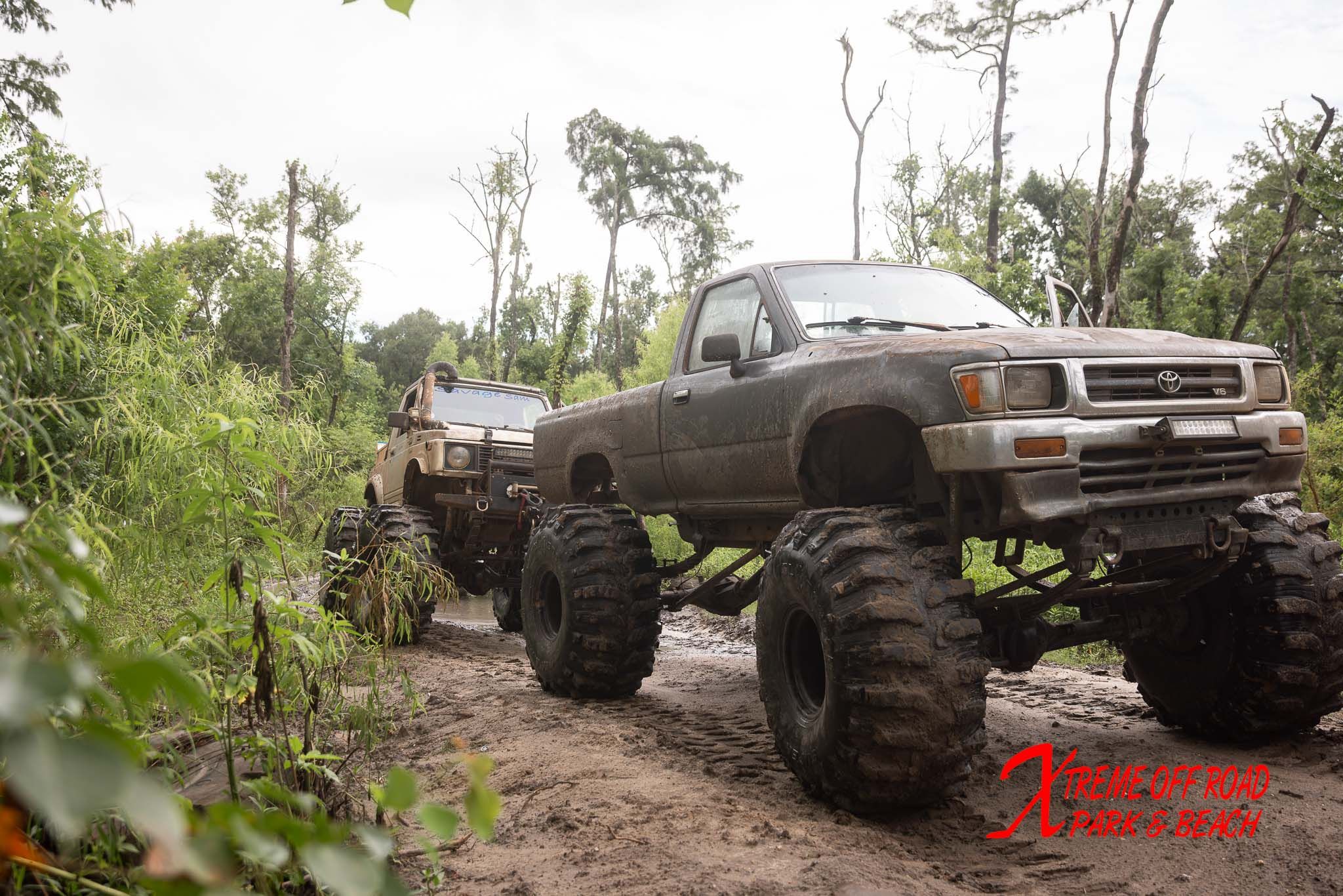 Lifted off-road trucks on a wooded trail at Xtreme Off Road Park