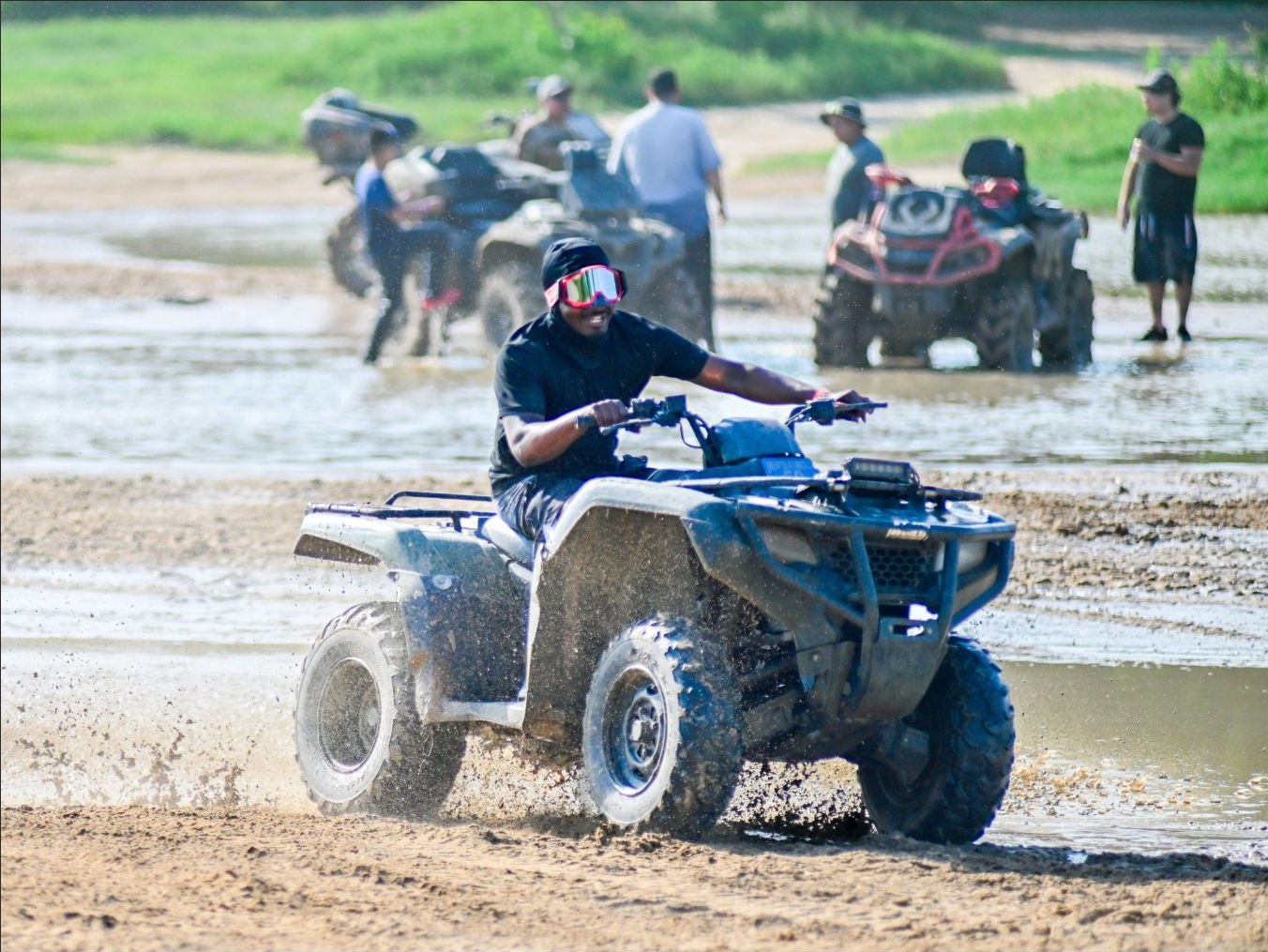 Honda Rancher ATV rider splashing through a water crossing at Xtreme Off Road Park