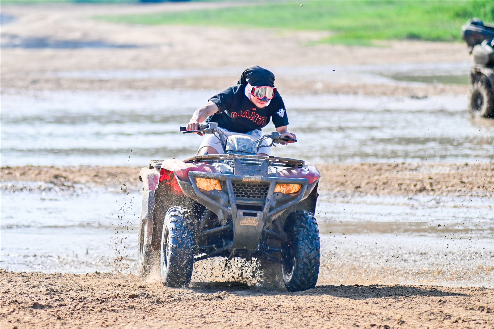 Can-Am Outlander rider crossing a muddy trail at Xtreme Off Road Park
